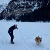 Katherine Long '15 in Tajikistan with a dog and snowy mountains in the background