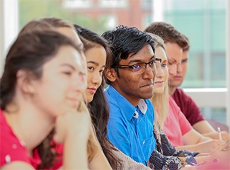 Students listen intently to a speaker 