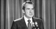 President Nixon speaks into a microphone in this black and white photo