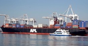 A container ship floats with dozens of cargo containers on board