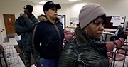 Three people wait in line to receive food stamps 