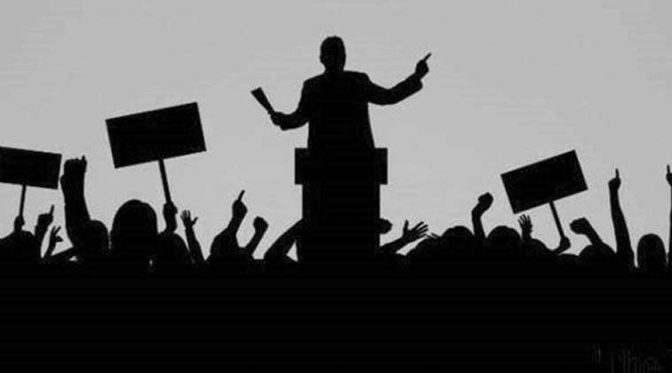silhouette of a man at a podium speaker to a crowd 